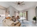 Bright living room featuring high ceilings, neutral tones, ceiling fan, and sliding glass doors to a screened in lanai at 1903 Sprucewood Way, Port Orange, FL 32128