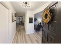 Inviting foyer with wood-look floors, modern light fixture, and a decorative wreath on the front door at 208 Wellington Dr, Daytona Beach, FL 32119