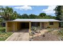 A cozy one-story home features a covered carport and artful drought-tolerant front yard landscaping at 2107 Saxon Dr, New Smyrna Beach, FL 32169