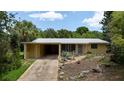 Inviting one-story home with a covered carport and drought-resistant plantings in the front yard at 2107 Saxon Dr, New Smyrna Beach, FL 32169