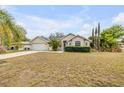 Inviting single-story home with a manicured lawn, lush landscaping, and an attached garage at 2435 Alton Rd, Deltona, FL 32738