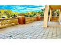 A large tiled balcony featuring trees and the sky in the background, with a stone railing at 250 Minorca Beach Way # 206, New Smyrna Beach, FL 32169