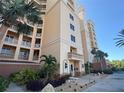 Condo building featuring multiple balconies and an inviting entrance surrounded by palm trees, benches, and tropical plants at 250 Minorca Beach Way # 206, New Smyrna Beach, FL 32169