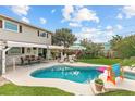 Inviting backyard pool with spa, shaded patio, green grass, and privacy fence at 2510 S Atlantic Ave, New Smyrna Beach, FL 32169