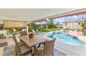 A covered outdoor dining area next to the swimming pool and manicured backyard at 2510 S Atlantic Ave, New Smyrna Beach, FL 32169
