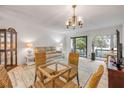 Bright living room with a glass table, cozy seating, and a balcony at 257 Club House Blvd, New Smyrna Beach, FL 32168