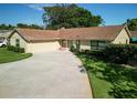 Inviting single-story home featuring a circular driveway, two car garage and manicured landscaping at 257 Sweet Bay Dr, New Smyrna Beach, FL 32168