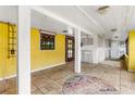 Bright sun room with yellow walls, tile flooring, and an decorative window with wood trim at 2576 Sunset Dr, New Smyrna Beach, FL 32168