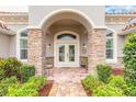 Inviting front entrance with stone pillars and colorful landscaping at 260 Portofino Blvd, New Smyrna Beach, FL 32168