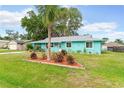 Well-maintained front yard with a palm tree in the center and flower beds surrounding the perimeter at 2726 Victory Palm Dr, Edgewater, FL 32141