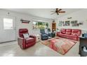 Cozy living room with tile flooring, comfortable seating, and bright natural light from the window at 2726 Victory Palm Dr, Edgewater, FL 32141