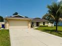 Inviting single-story home showcasing a wide driveway leading to an attached garage, complemented by a well-kept lawn at 3303 Victory Palm Dr, Edgewater, FL 32141