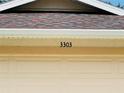 Close-up of the house number '3303' displayed above the garage door, accented by a textured roof at 3303 Victory Palm Dr, Edgewater, FL 32141