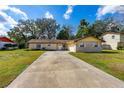 Charming single-story brick home with a well-manicured lawn and a long driveway leading to an attached garage at 3610 Donna St, Port Orange, FL 32129