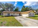 Charming single-story brick home with a well-manicured lawn and a long driveway leading to an attached garage at 3610 Donna St, Port Orange, FL 32129