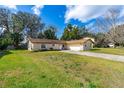 Charming single-story brick home with a well-manicured lawn and a long driveway leading to an attached garage at 3610 Donna St, Port Orange, FL 32129