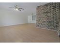 Spacious living room featuring neutral walls, light wood flooring, and brick accent wall at 3736 Paige St, Port Orange, FL 32129