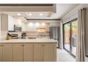 Charming kitchen featuring white cabinets, stainless steel appliances, and sliding glass doors at 3808 Saxon Dr, New Smyrna Beach, FL 32169