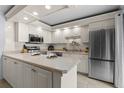 Bright kitchen with stainless appliances, light cabinets, and tile floors at 3808 Saxon Dr, New Smyrna Beach, FL 32169