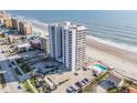 Aerial view of a condo building near the beach featuring balconies, a pool, parking, and neighborhood condos at 3855 S Atlantic Ave # 1503, Daytona Beach Shores, FL 32118