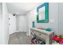 Hallway featuring a decorative mirror, tiled floors, white doors, and stylish decor at 3855 S Atlantic Ave # 1503, Daytona Beach Shores, FL 32118