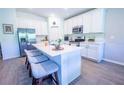 Bright, all-white kitchen features a center island with seating, stainless steel appliances, and modern finishes at 3963 Willowbrook Dr, Edgewater, FL 32141