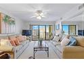 Well-lit living room with cozy sofas and balcony access at 4175 S Atlantic Ave # 4050, New Smyrna Beach, FL 32169