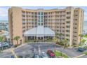 Exterior shot of a condo building with palm trees and a large parking lot at 421 S Atlantic Ave # 507, New Smyrna Beach, FL 32169