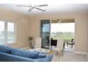 Bright living room with neutral tones, plush seating, and access to a scenic balcony at 426 Bouchelle Dr # 401, New Smyrna Beach, FL 32169