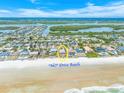 Aerial view of a quaint beach community with charming homes and ocean access along 'No Drive' Beach at 4323 S Atlantic Ave, Port Orange, FL 32127