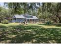 Expansive backyard with lush green grass and mature trees, offering privacy and space for outdoor activities at 4580 Lake James Cir, Edgewater, FL 32141