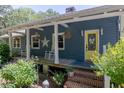 Inviting front porch with rocking chairs and a bright yellow door, perfect for relaxing outdoors at 4580 Lake James Cir, Edgewater, FL 32141