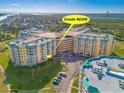 An aerial view shows Condo D206 in a bright yellow building with golf course and landscaping at 4670 Links Village Dr # D206, Ponce Inlet, FL 32127