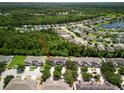 An aerial view of a neighborhood with mature trees, a lake, and well-maintained homes at 567 Mount Olympus Blvd, New Smyrna Beach, FL 32168