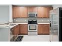 An updated kitchen featuring stainless steel appliances, light countertops, and wood cabinets at 567 Mount Olympus Blvd, New Smyrna Beach, FL 32168