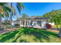 Attractive single-story home with arched windows, a well-kept lawn, and mature landscaping at 6088 Sabal Hammock Cir, Port Orange, FL 32128