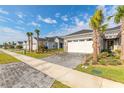 Beautiful street view of modern homes with lush landscaping, paver driveways, and palm trees at 6456 Roseberry Ct, Port Orange, FL 32128