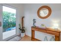 Bright entryway features a wood console table with decorative accents and a round mirror at 6530 S Atlantic Ave, New Smyrna Beach, FL 32169