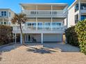 Coastal home featuring balconies, a paver driveway, and a convenient under-house garage for parking at 6530 S Atlantic Ave, New Smyrna Beach, FL 32169