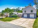 Exterior of home and a spacious building in the rear, showcasing a long, paved driveway at 830 Christy Dr, Port Orange, FL 32129