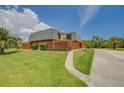 Two-story home with a Mansard roof, green lawn, walkway, and a partial view of the balcony at 90 Cedar Dunes Dr, New Smyrna Beach, FL 32169