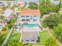 Aerial view of backyard featuring a large swimming pool, spa, lounge chairs, and a detached guest house at 90 Cunningham Dr, New Smyrna Beach, FL 32168