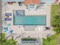 Aerial view of a backyard pool and spa with pavers, lounge chairs, and a detached guest house at 90 Cunningham Dr, New Smyrna Beach, FL 32168