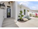 Close up of the front entrance with a modern black door and manicured landscaping with a rock feature at 102 Inlet Shores Dr, New Smyrna Beach, FL 32168