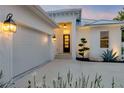 Welcoming front entrance featuring a modern black door, and landscaped accents at 102 Inlet Shores Dr, New Smyrna Beach, FL 32168