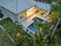 Aerial view showcasing a private backyard oasis with a pool, spa, outdoor seating, and lush landscaping at 102 Inlet Shores Dr, New Smyrna Beach, FL 32168