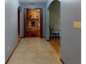 Arched hallway with tile flooring leading to a cozy living room with a stone fireplace at 108 Dee St, New Smyrna Beach, FL 32168