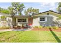 Attractive home exterior with well-maintained landscaping and a bright red front door at 1144 Corbin Park Rd, New Smyrna Beach, FL 32168