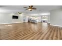 Open-concept living room featuring hardwood floors and a view of the modern kitchen at 1144 Corbin Park Rd, New Smyrna Beach, FL 32168