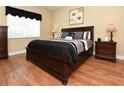 Elegant bedroom with a dark wood bed frame, stylish bedding, and hardwood floors at 1442 Carlow Cir, Ormond Beach, FL 32174